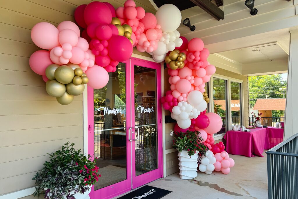 retail storefront with pink doors and balloons